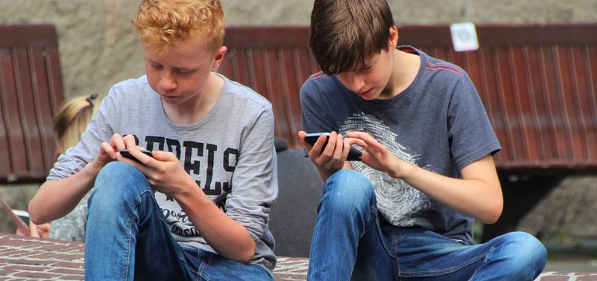 Deux enfants sur leurs smartphones.